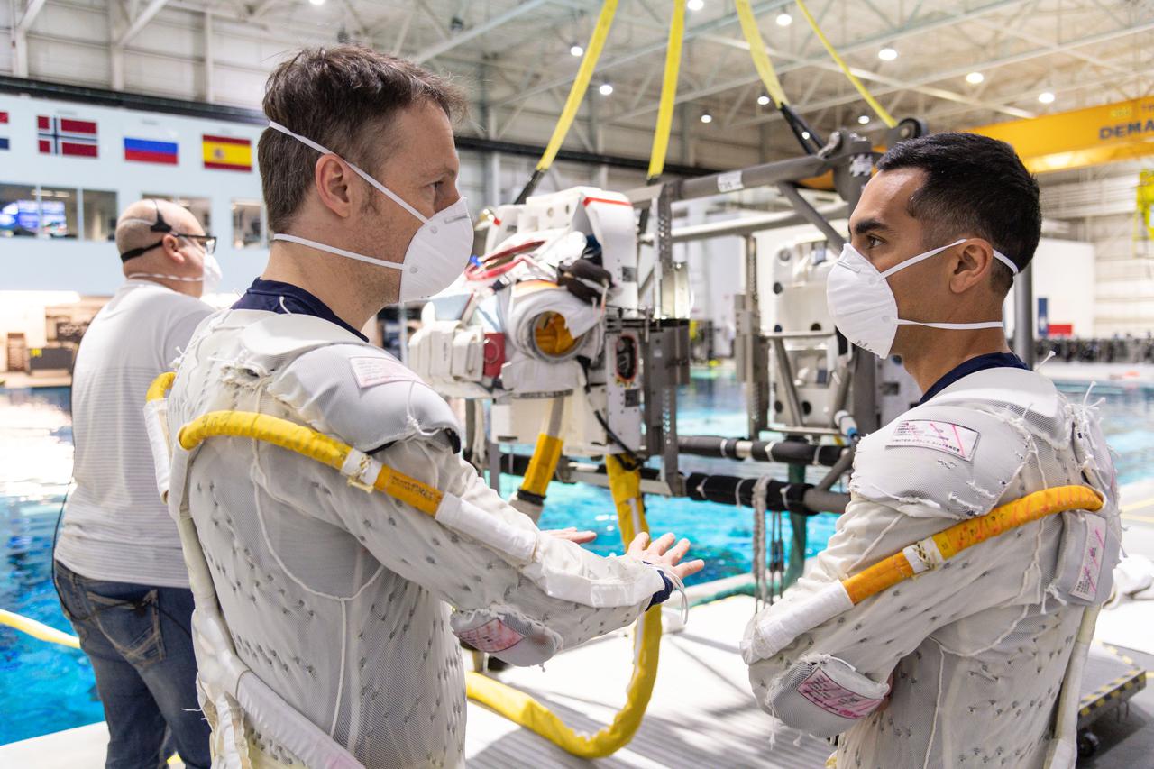 jsc2021e012468 (April 1, 2021) --- SpaceX Crew-3 astronauts (from left) Matthias Maurer and Raja Chari prepare for spacewalk training at the Neutral Buoyancy Laboratory at NASA's Johnson Space Center in Houston, Texas.