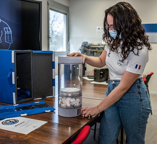 jsc2021e029981 (3/18/2021) --- A Picture of the EKLOSION pot manipulated by Eve Teyssier at CNES Toulouse. The Eklosion investigation consist of a vase that is utilized by a crew member to grow a Marigold flower (Tagetes patula) aboard the ISS. The investigation takes place at the leisure of the crew member and helps to study the process of plant growth in space, as well as using a personally tended house plant in space to help establish a psychological link between the crew member aboard the ISS and Earth. Image courtesy of CNES.