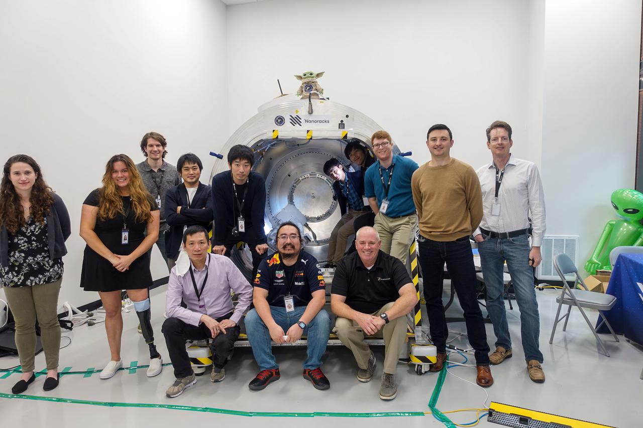 jsc2021e036652 (8/11/2021) --- The GITAI and Nanoracks team group photo. The GITAI S1 Robotic Arm Tech Demo (Nanoracks-GITAI Robotic Arm) demonstrates the versatility and dexterity in microgravity of a robot designed by GITAI Japan Inc. For the demonstration, the robot conducts common crew activities and tasks via supervised autonomy and teleoperations from the ground.