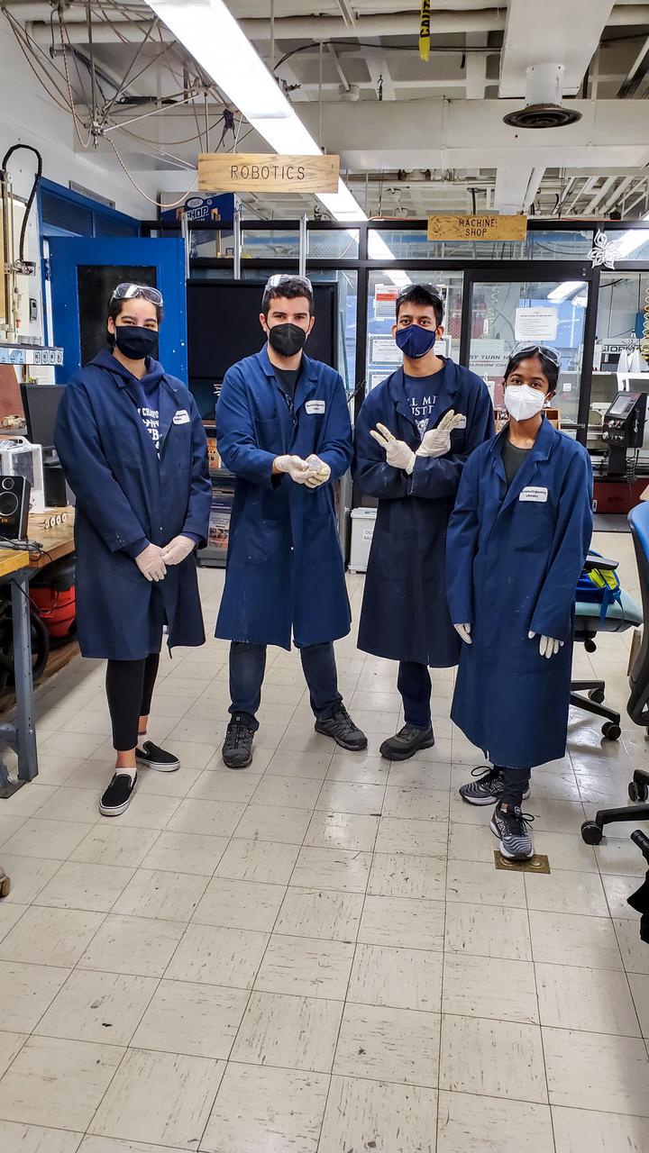jsc2021e063274 (3/17/2021) --- Preflight imagery for the Characterizing Antibiotic Resistance in Microgravity Environments (CARMEn) experiment, part of Nanoracks Module-96. CARMEn observes how spaceflight affects the growth of a culture of two species of bacteria. The Mechanical Engineering team is pictured in the Mechanical Engineering Shop with connector piece. From left to right: Deanna Duqmaq, Alfonso Ussia, Gaurav Kulkarni, Kalpana Ganeshan.