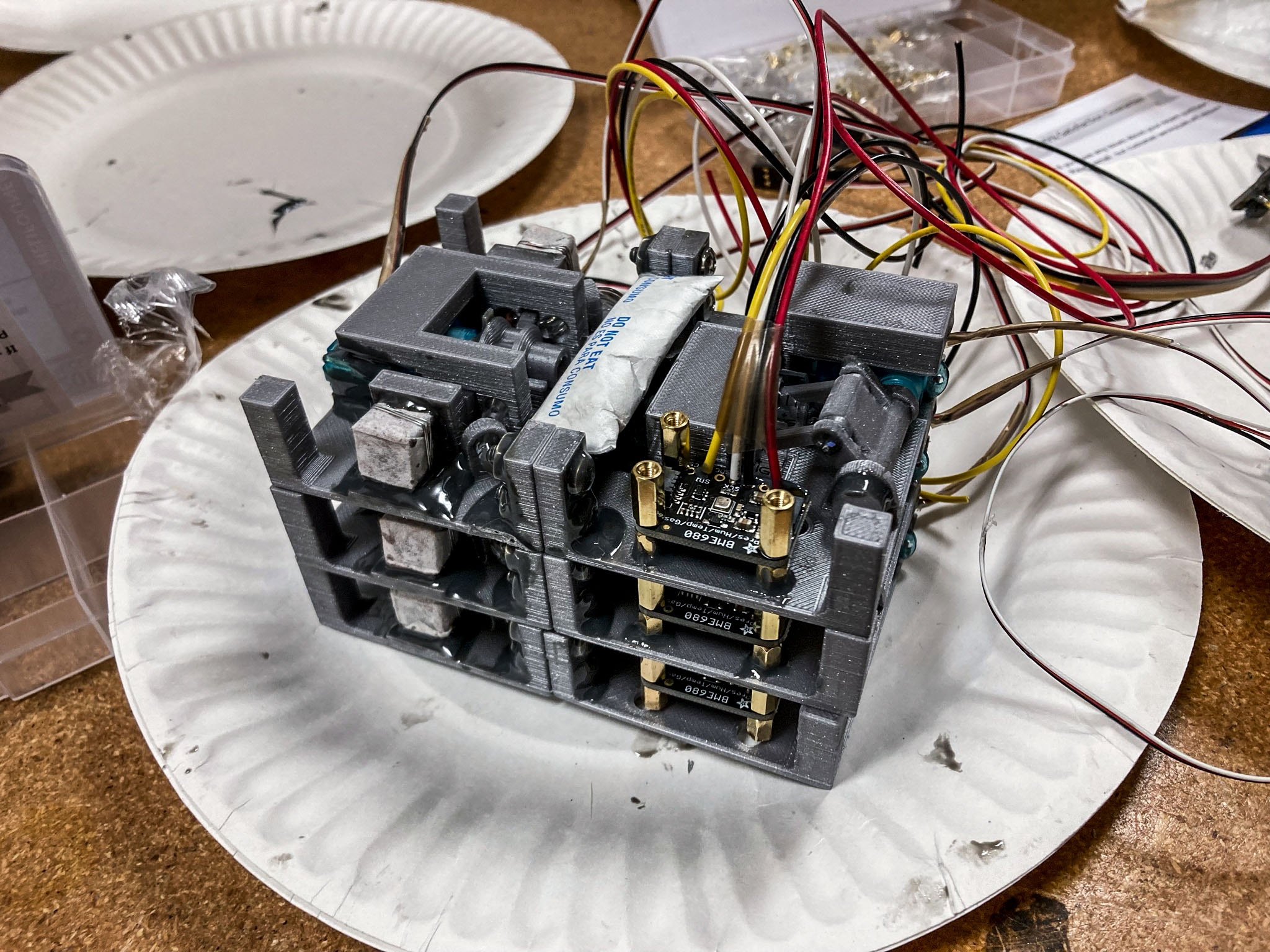 jsc2022e042479 (2/3/2022) --- This image shows three modules of flight hardware for the Biopolymer Research for In-Situ Capabilities investigation, launching aboard SpaceX’s 25th commercial resupply services mission to the International Space Station. The hardware is 3D printed in gray PLA, a desiccant packet is epoxied in the center of the module, and a pressure and humidity sensor is fastened to the left. Each module makes two bricks, for a total of six bricks that will be made in space. This investigation studies how microgravity affects the process of creating biopolymer soil composite (BSC), a concrete alternative that could be made with on-site material such as lunar or Martian dust. Image curtsey of James Wall.
