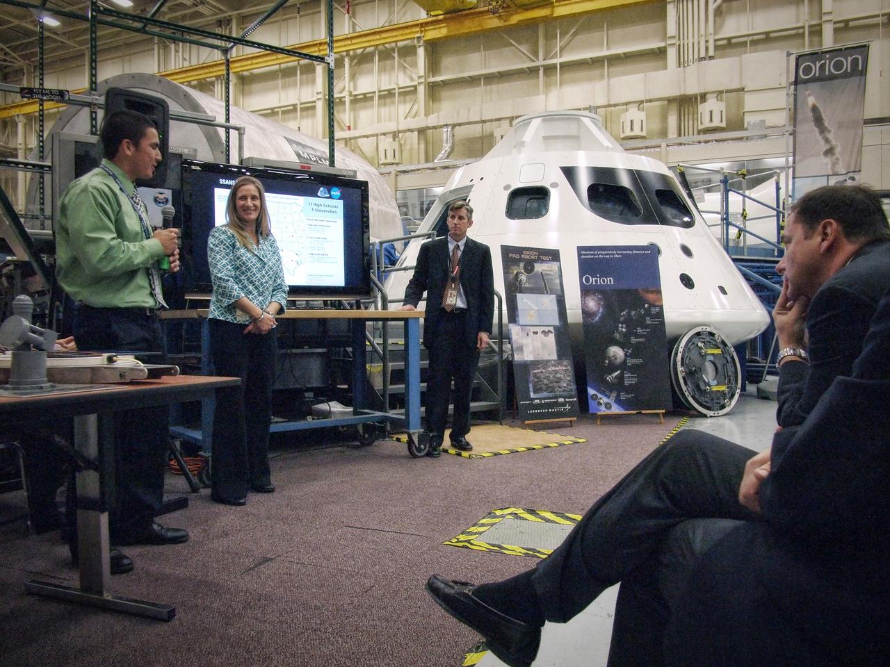 Jeff Fox, Christie Sauers, and Phillip Reyes present the Students Shaping America's Next Spacecraft (SSANS) program to NASA center directors in front of the Orion mockup in Building 9 at Johnson Space Center in Houston on Nov. 10, 2011. Part of Batch image transfer from Flickr.