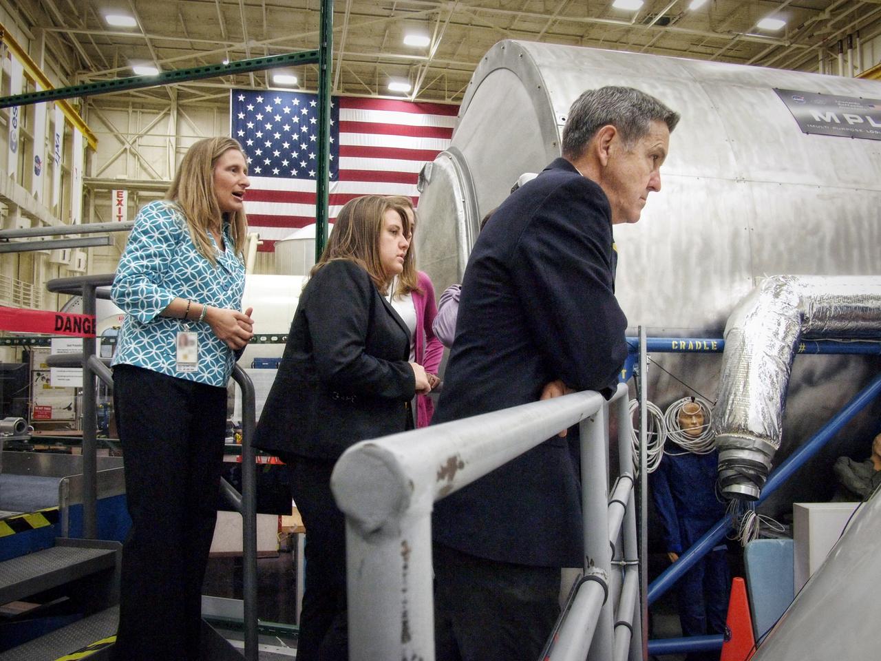 Kennedy Space Center Director Robert Cabana looks into the Orion medium fidelity mockup as Christi Sauers describes the work performed by Students Shaping America's Next Spacecraft (SSANS) program in Building 9 at Johnson Space Center in Houston on Nov. 10, 2011. Part of Batch image transfer from Flickr.