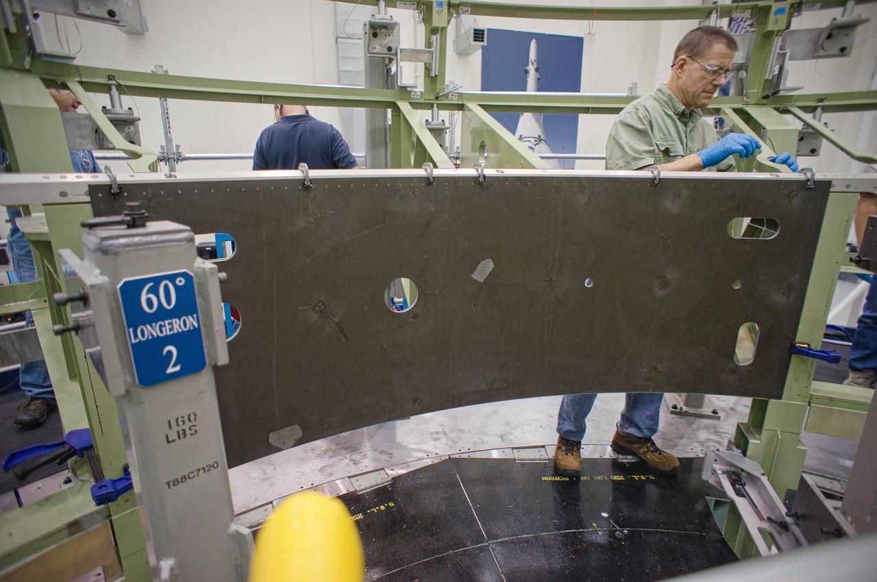 Technicians install the first composite panel on the Exploration Flight Test-1 (EFT-1) Orion service module in the Operations and Checkout (O&C) Building at NASA’s Kennedy Space Center on Dec. 31, 2011. Part of Batch image transfer from Flickr.