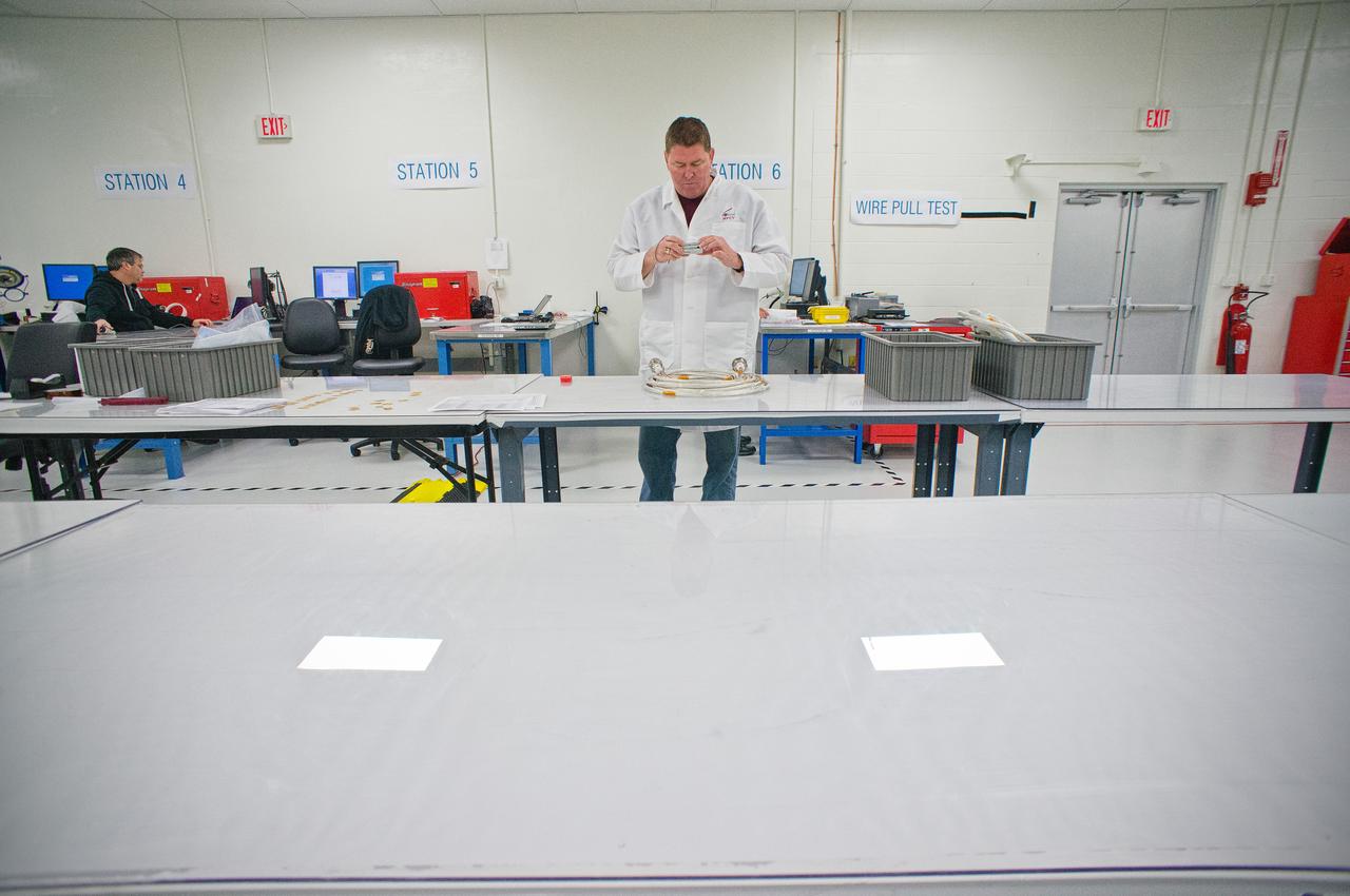 Technicians work on the harness assembly for the Exploration Flight Test-1 (EFT-1) Orion in the Operations and Checkout (O&amp;C) Building at NASA’s Kennedy Space Center on Jan. 1, 2012.  Part of Batch image transfer from Flickr. 