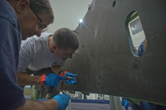 NASA image: Drilling pilot holes in composite Service Module panel clamped t
