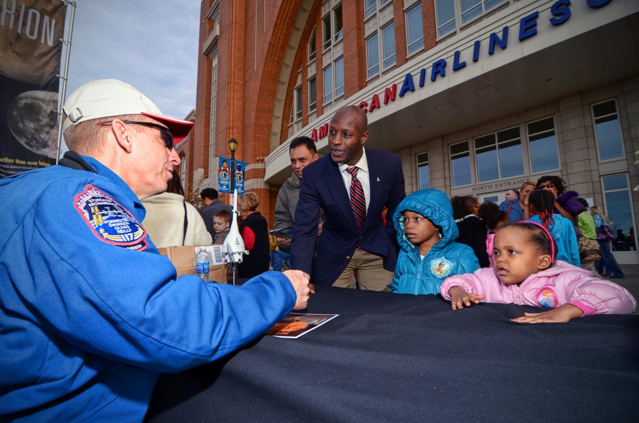Astronaut signs autographs for visitors during Orion Pad Abort-1 pathfinder display at an event outside American Airlines Center in Dallas on Jan. 27, 2012. Part of Batch image transfer from Flickr.