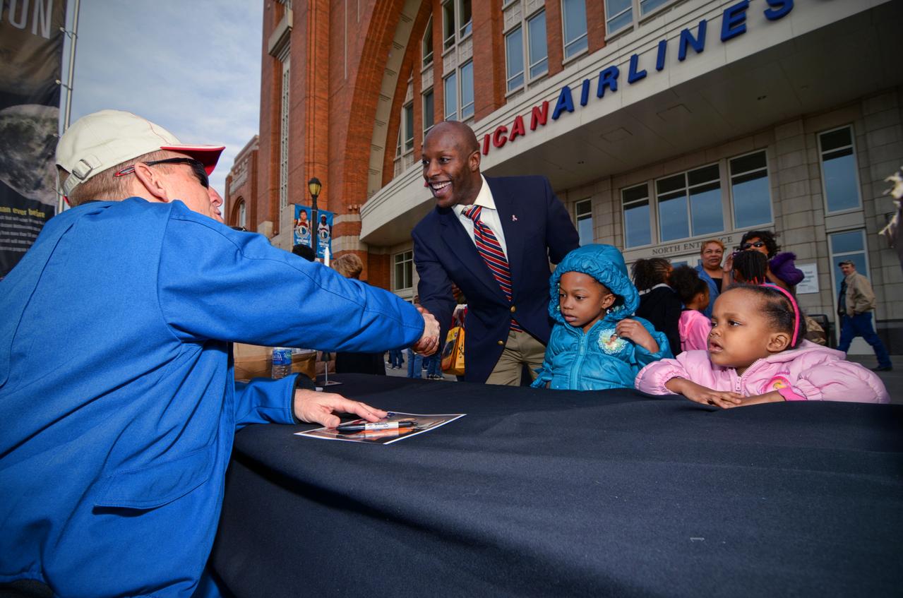 Astronaut signs autographs for visitors during Orion Pad Abort-1 pathfinder display at an event outside American Airlines Center in Dallas on Jan. 27, 2012. Part of Batch image transfer from Flickr.