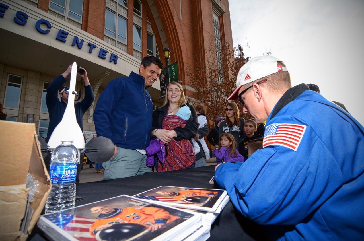 Astronaut signs autographs for visitors during Orion Pad Abort-1 pathfinder display at an event outside American Airlines Center in Dallas on Jan. 27, 2012. Part of Batch image transfer from Flickr.