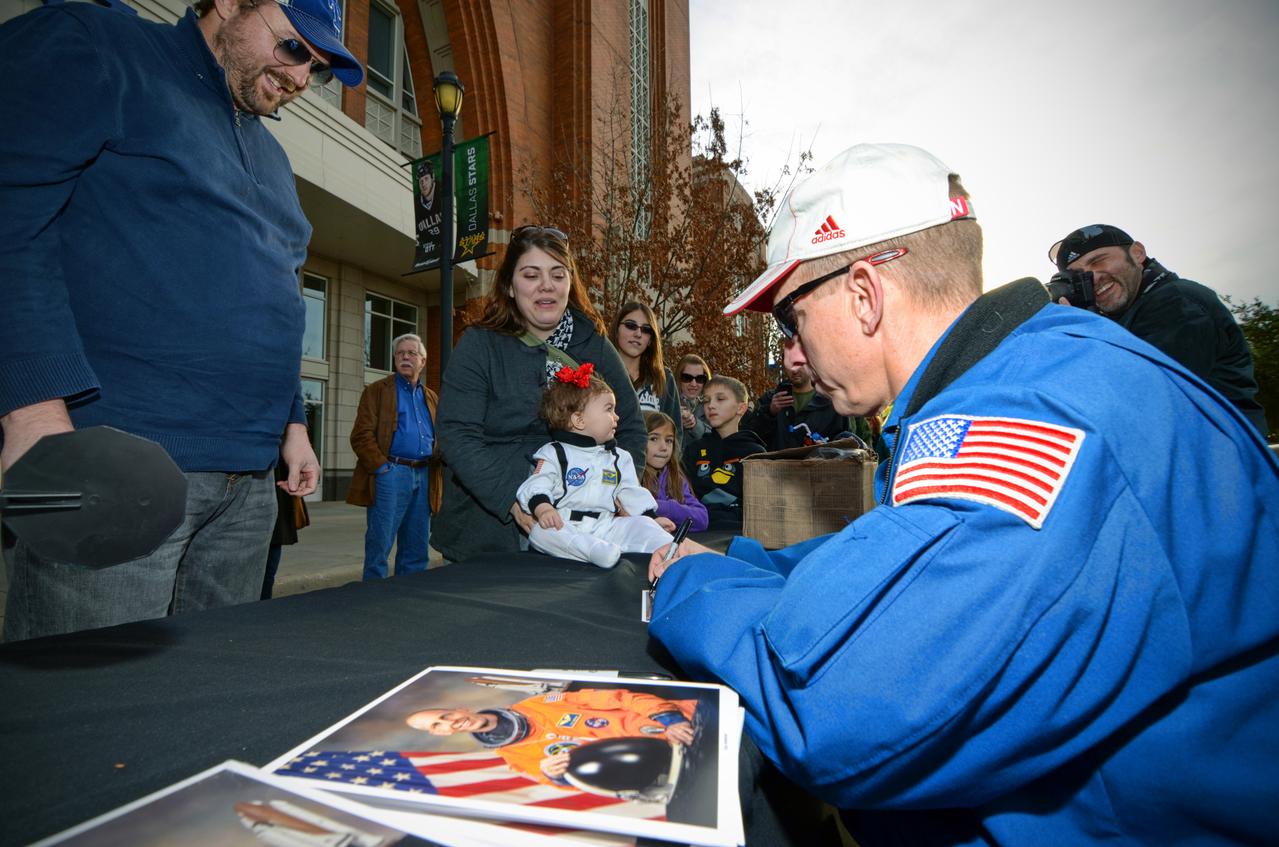 Astronaut signs autographs for visitors during Orion Pad Abort-1 pathfinder display at an event outside American Airlines Center in Dallas on Jan. 27, 2012. Part of Batch image transfer from Flickr.