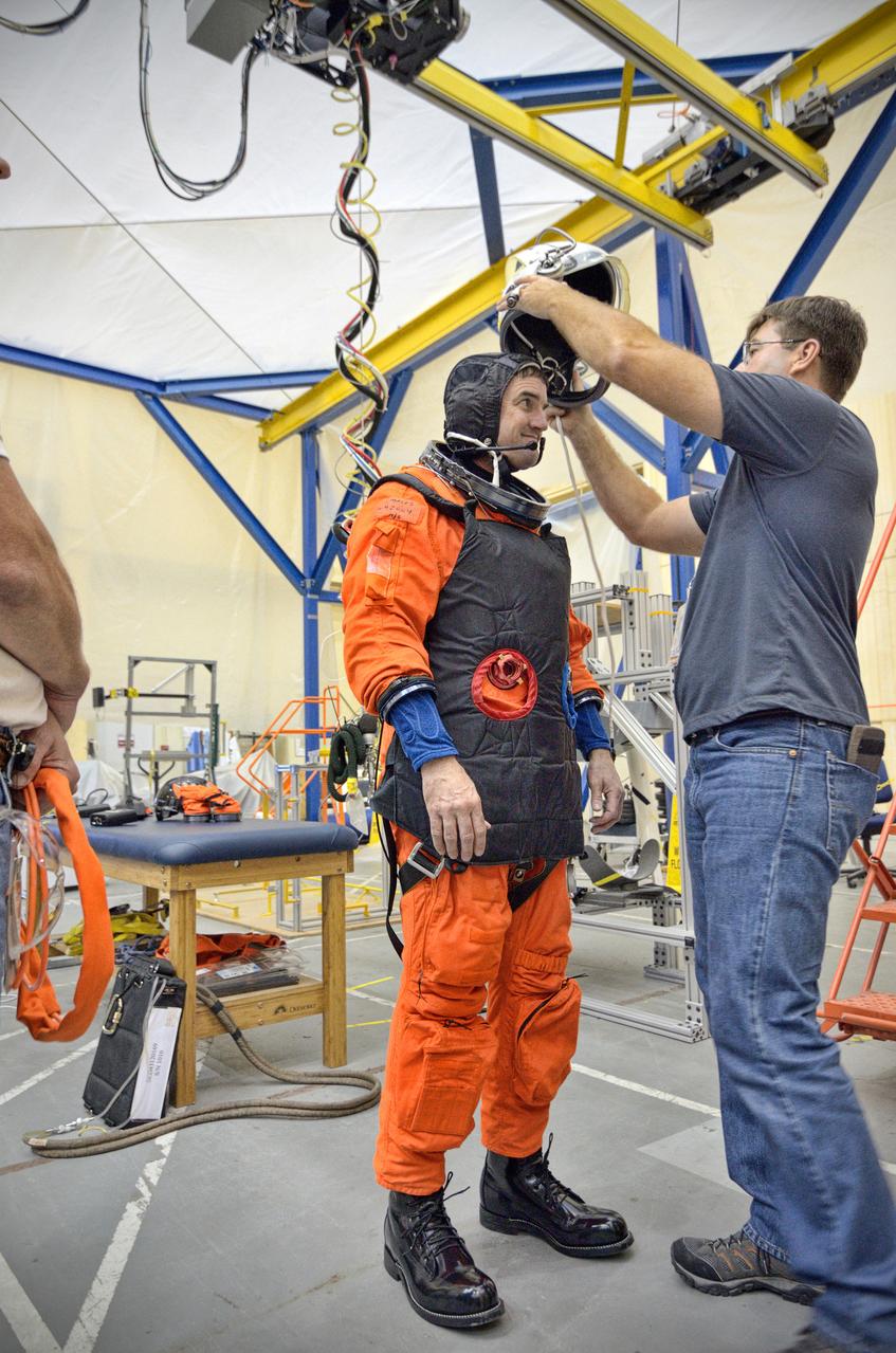Astronaut Rex Walheim uses the Active Response Gravity Offload System (ARGOS) to perform early evaluations of the Orion Crew Survival System (OCSS) suit in Building 9 of Johnson Space Center in Houston on June 5, 2012. ARGOS is designed to simulate reduced gravity environments, such as lunar, Martian, or microgravity, using a system similar to an overhead bridge crane. Part of Batch image transfer from Flickr.