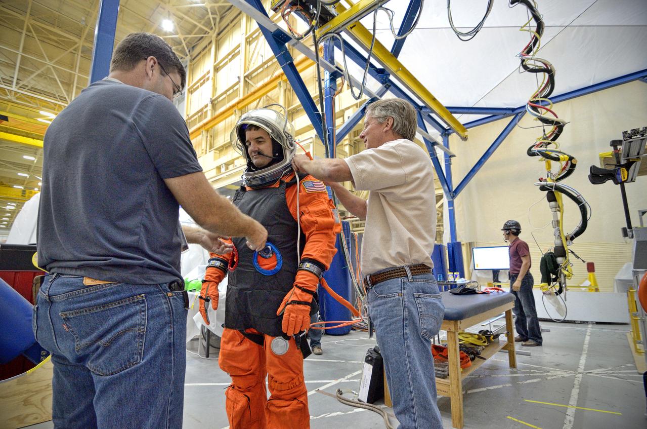Astronaut Rex Walheim uses the Active Response Gravity Offload System (ARGOS) to perform early evaluations of the Orion Crew Survival System (OCSS) suit in Building 9 of Johnson Space Center in Houston on June 5, 2012. ARGOS is designed to simulate reduced gravity environments, such as lunar, Martian, or microgravity, using a system similar to an overhead bridge crane. Part of Batch image transfer from Flickr.