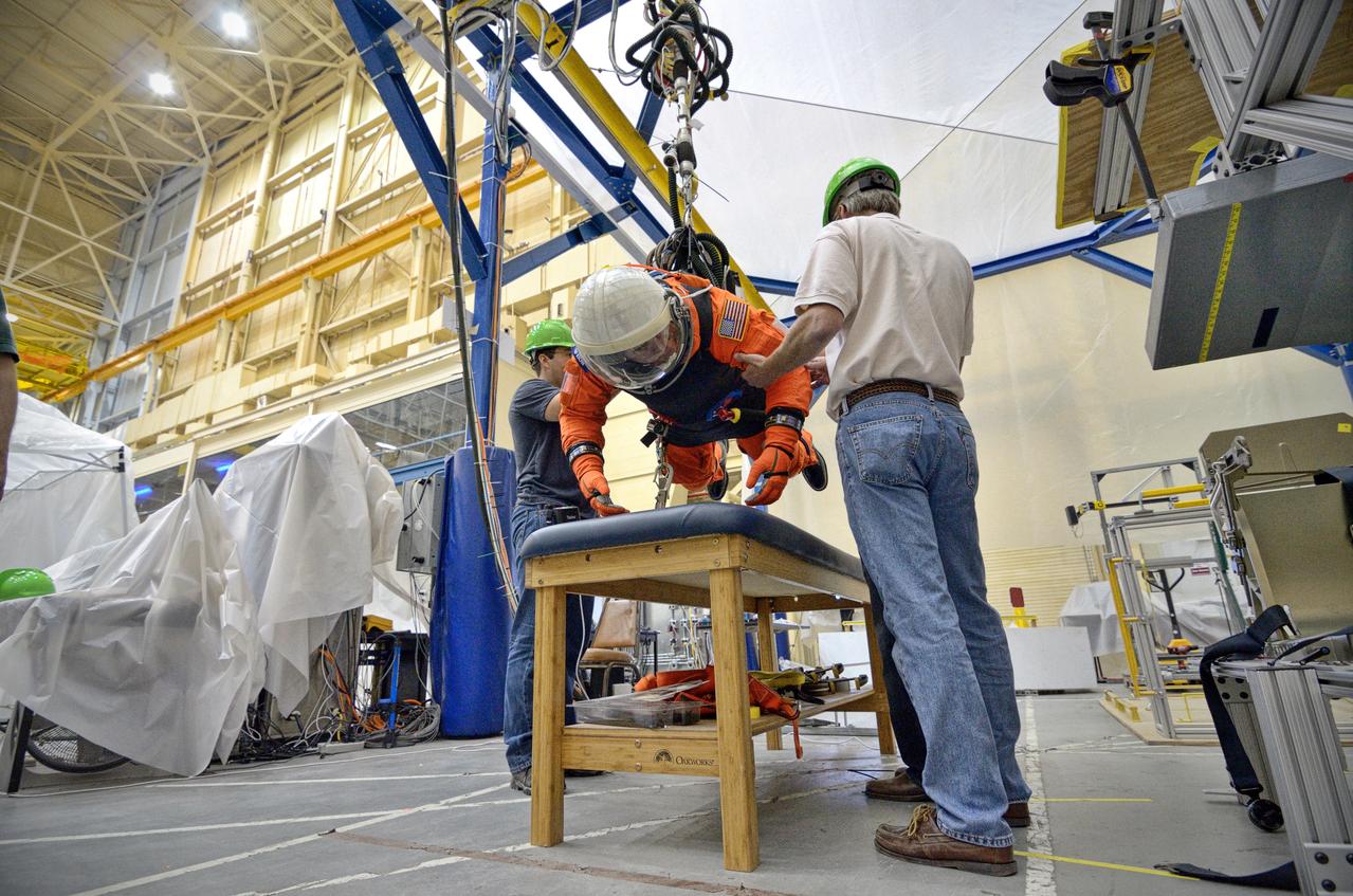 Astronaut Rex Walheim uses the Active Response Gravity Offload System (ARGOS) to perform early evaluations of the Orion Crew Survival System (OCSS) suit in Building 9 of Johnson Space Center in Houston on June 5, 2012. ARGOS is designed to simulate reduced gravity environments, such as lunar, Martian, or microgravity, using a system similar to an overhead bridge crane. Part of Batch image transfer from Flickr.