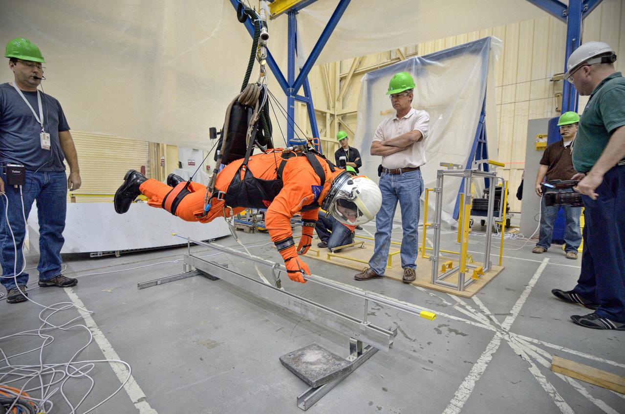 Astronaut Rex Walheim uses the Active Response Gravity Offload System (ARGOS) to perform early evaluations of the Orion Crew Survival System (OCSS) suit in Building 9 of Johnson Space Center in Houston on June 5, 2012. ARGOS is designed to simulate reduced gravity environments, such as lunar, Martian, or microgravity, using a system similar to an overhead bridge crane. Part of Batch image transfer from Flickr.