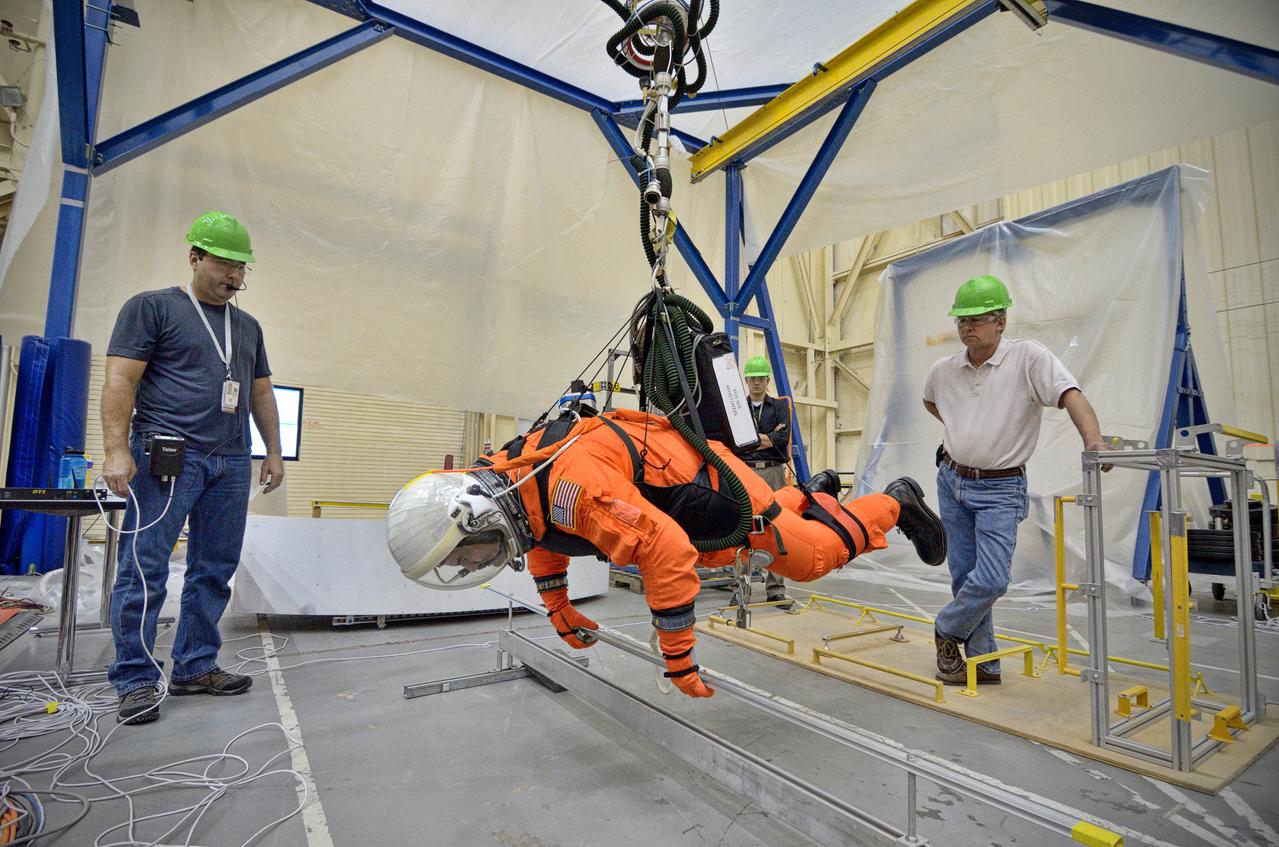 Astronaut Rex Walheim uses the Active Response Gravity Offload System (ARGOS) to perform early evaluations of the Orion Crew Survival System (OCSS) suit in Building 9 of Johnson Space Center in Houston on June 5, 2012. ARGOS is designed to simulate reduced gravity environments, such as lunar, Martian, or microgravity, using a system similar to an overhead bridge crane. Part of Batch image transfer from Flickr.