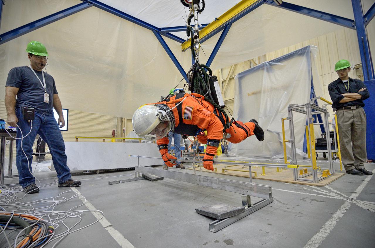 Astronaut Rex Walheim uses the Active Response Gravity Offload System (ARGOS) to perform early evaluations of the Orion Crew Survival System (OCSS) suit in Building 9 of Johnson Space Center in Houston on June 5, 2012. ARGOS is designed to simulate reduced gravity environments, such as lunar, Martian, or microgravity, using a system similar to an overhead bridge crane. Part of Batch image transfer from Flickr.