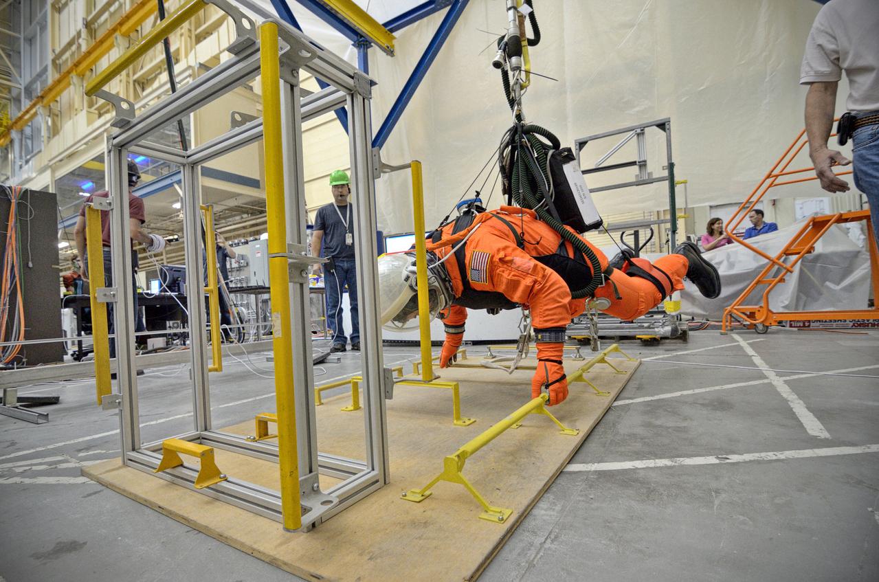 Astronaut Rex Walheim uses the Active Response Gravity Offload System (ARGOS) to perform early evaluations of the Orion Crew Survival System (OCSS) suit in Building 9 of Johnson Space Center in Houston on June 5, 2012. ARGOS is designed to simulate reduced gravity environments, such as lunar, Martian, or microgravity, using a system similar to an overhead bridge crane. Part of Batch image transfer from Flickr.