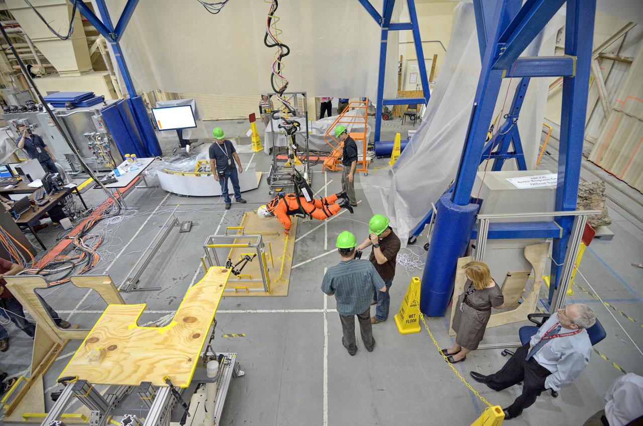 Astronaut Rex Walheim uses the Active Response Gravity Offload System (ARGOS) to perform early evaluations of the Orion Crew Survival System (OCSS) suit in Building 9 of Johnson Space Center in Houston on June 5, 2012. ARGOS is designed to simulate reduced gravity environments, such as lunar, Martian, or microgravity, using a system similar to an overhead bridge crane. Part of Batch image transfer from Flickr.