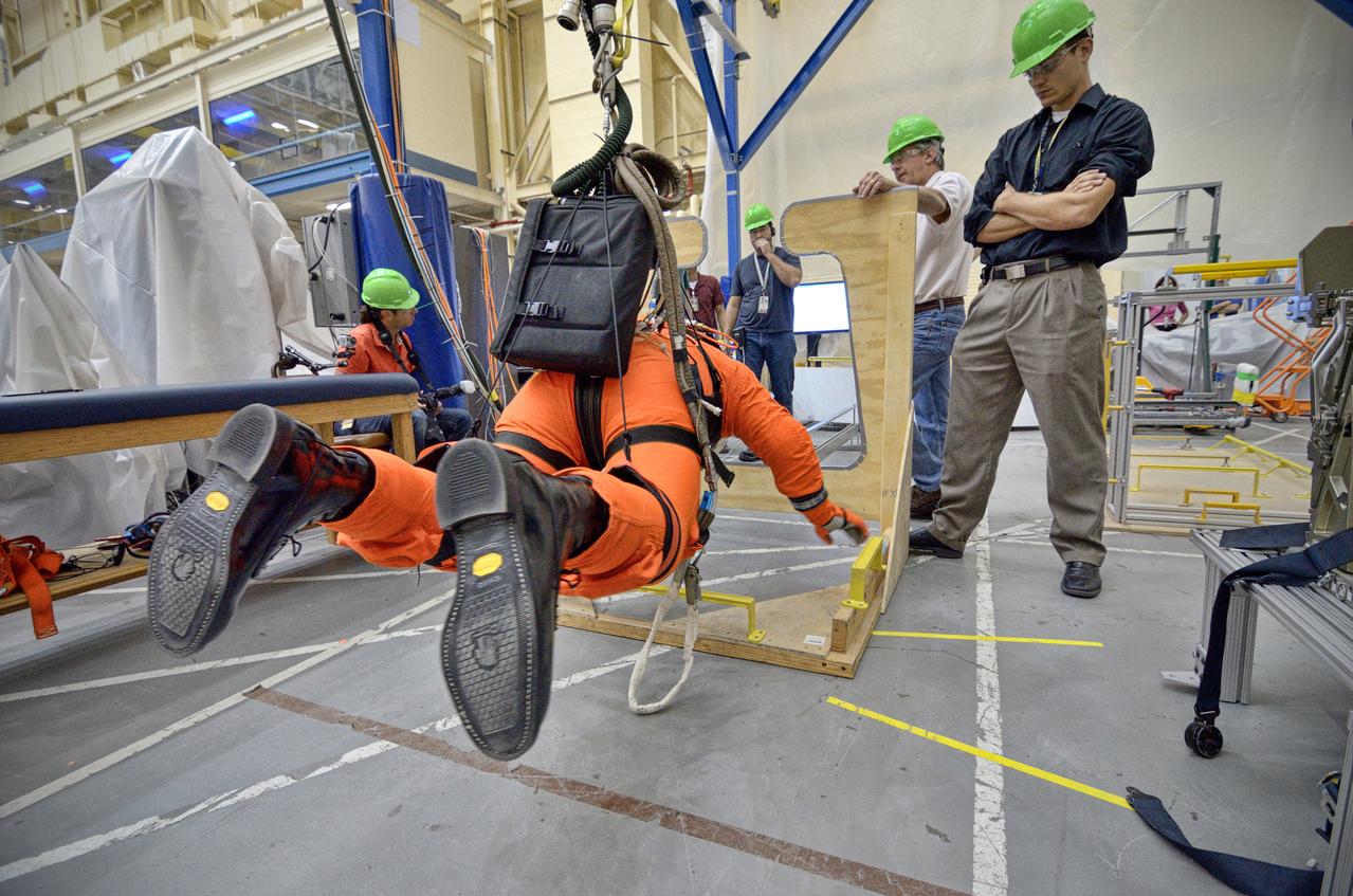 Astronaut Rex Walheim uses the Active Response Gravity Offload System (ARGOS) to perform early evaluations of the Orion Crew Survival System (OCSS) suit in Building 9 of Johnson Space Center in Houston on June 5, 2012. ARGOS is designed to simulate reduced gravity environments, such as lunar, Martian, or microgravity, using a system similar to an overhead bridge crane. Part of Batch image transfer from Flickr.