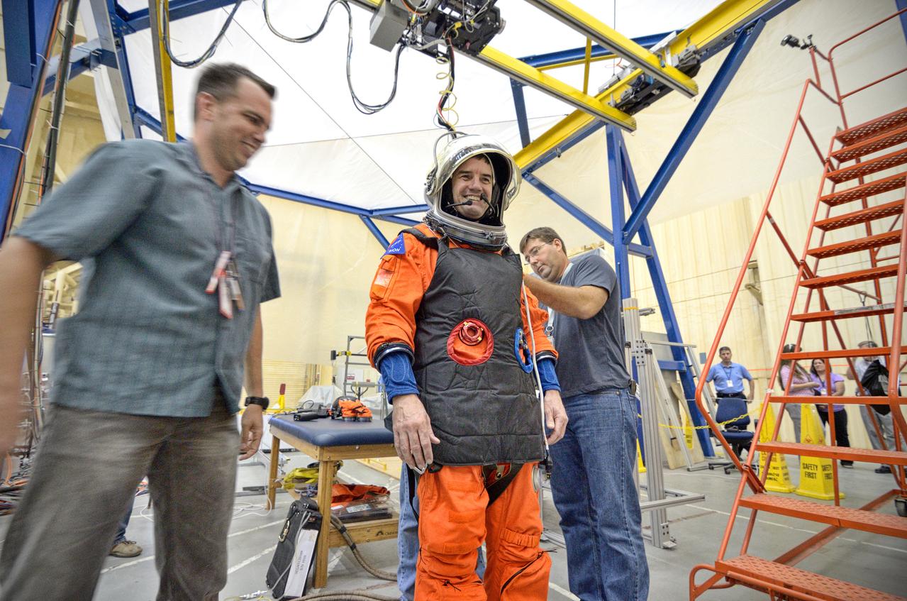 Astronaut Rex Walheim uses the Active Response Gravity Offload System (ARGOS) to perform early evaluations of the Orion Crew Survival System (OCSS) suit in Building 9 of Johnson Space Center in Houston on June 5, 2012. ARGOS is designed to simulate reduced gravity environments, such as lunar, Martian, or microgravity, using a system similar to an overhead bridge crane. Part of Batch image transfer from Flickr.