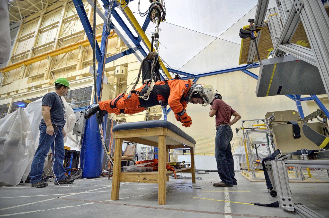 Astronaut Rex Walheim uses the Active Response Gravity Offload System (ARGOS) to perform early evaluations of the Orion Crew Survival System (OCSS) suit in Building 9 of Johnson Space Center in Houston on June 5, 2012. ARGOS is designed to simulate reduced gravity environments, such as lunar, Martian, or microgravity, using a system similar to an overhead bridge crane. Part of Batch image transfer from Flickr.