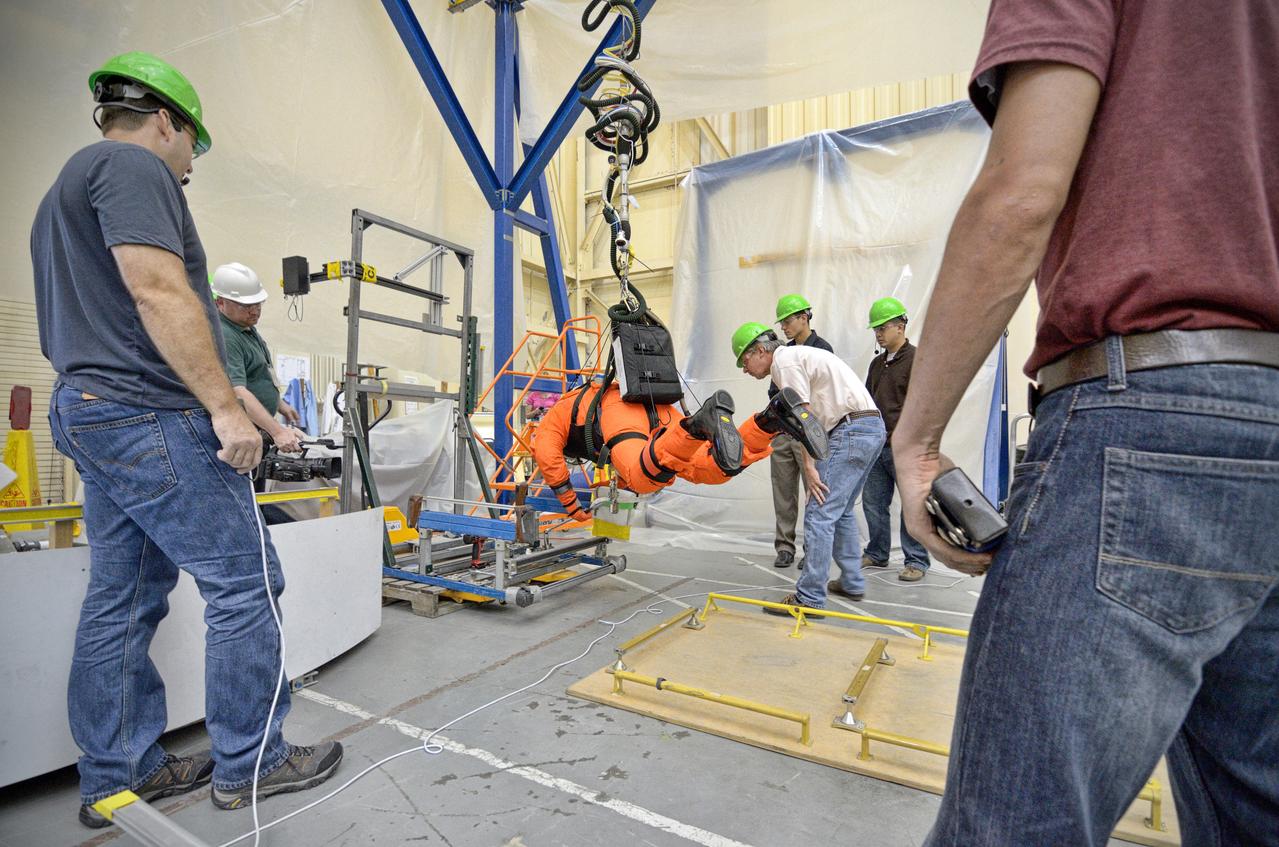 Astronaut Rex Walheim uses the Active Response Gravity Offload System (ARGOS) to perform early evaluations of the Orion Crew Survival System (OCSS) suit in Building 9 of Johnson Space Center in Houston on June 5, 2012. ARGOS is designed to simulate reduced gravity environments, such as lunar, Martian, or microgravity, using a system similar to an overhead bridge crane. Part of Batch image transfer from Flickr.