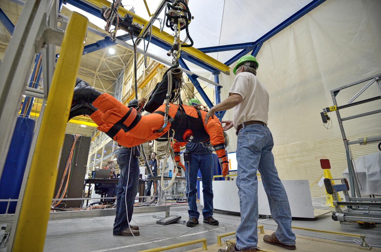 Astronaut Rex Walheim uses the Active Response Gravity Offload System (ARGOS) to perform early evaluations of the Orion Crew Survival System (OCSS) suit in Building 9 of Johnson Space Center in Houston on June 5, 2012. ARGOS is designed to simulate reduced gravity environments, such as lunar, Martian, or microgravity, using a system similar to an overhead bridge crane. Part of Batch image transfer from Flickr.