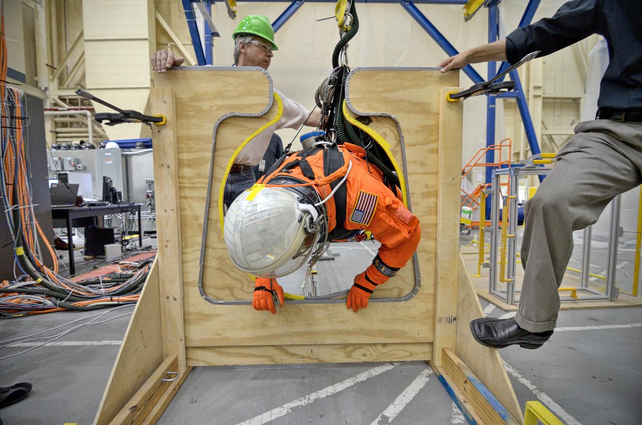 Astronaut Rex Walheim uses the Active Response Gravity Offload System (ARGOS) to perform early evaluations of the Orion Crew Survival System (OCSS) suit in Building 9 of Johnson Space Center in Houston on June 5, 2012. ARGOS is designed to simulate reduced gravity environments, such as lunar, Martian, or microgravity, using a system similar to an overhead bridge crane. Part of Batch image transfer from Flickr.
