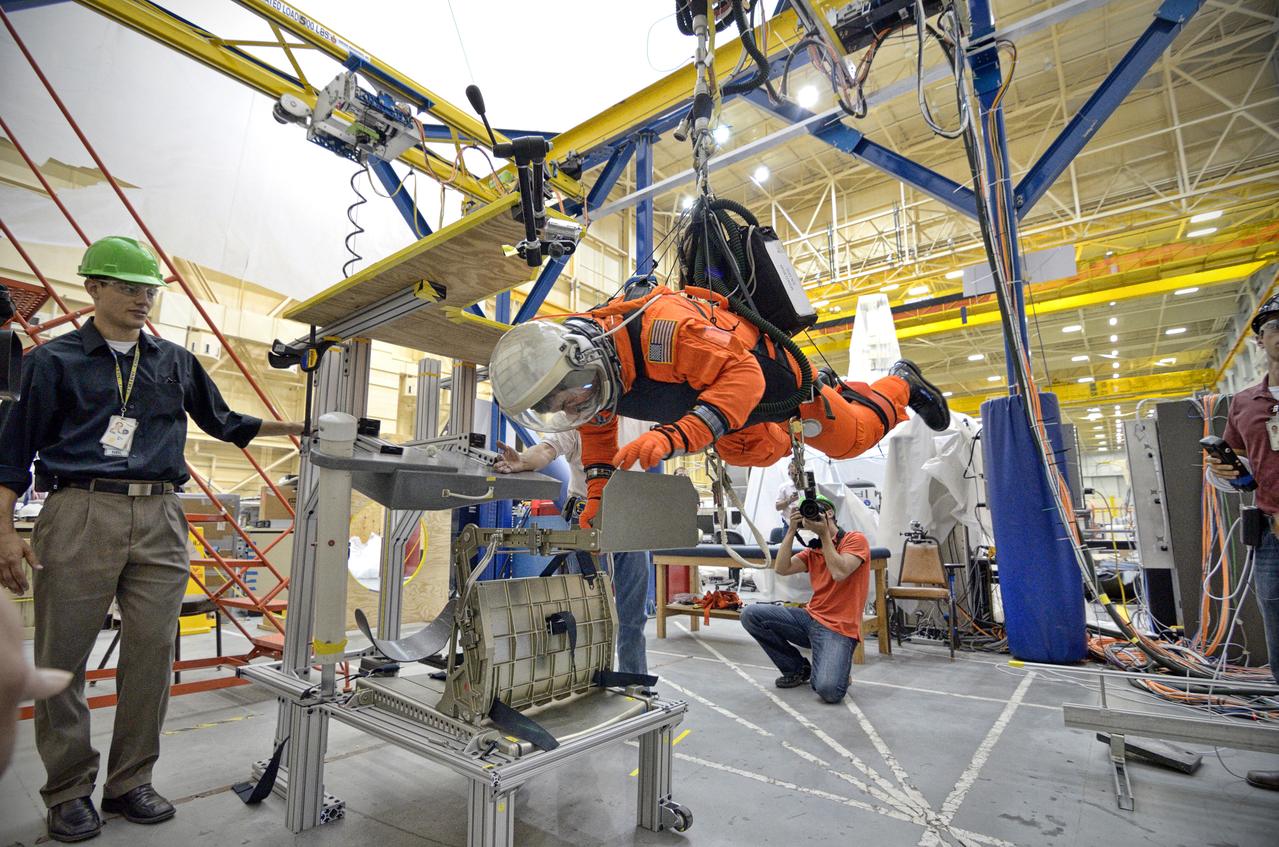 Astronaut Rex Walheim uses the Active Response Gravity Offload System (ARGOS) to perform early evaluations of the Orion Crew Survival System (OCSS) suit in Building 9 of Johnson Space Center in Houston on June 5, 2012. ARGOS is designed to simulate reduced gravity environments, such as lunar, Martian, or microgravity, using a system similar to an overhead bridge crane. Part of Batch image transfer from Flickr.