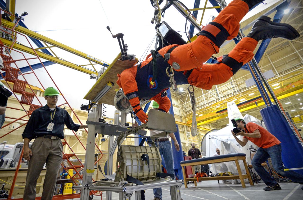 Astronaut Rex Walheim uses the Active Response Gravity Offload System (ARGOS) to perform early evaluations of the Orion Crew Survival System (OCSS) suit in Building 9 of Johnson Space Center in Houston on June 5, 2012. ARGOS is designed to simulate reduced gravity environments, such as lunar, Martian, or microgravity, using a system similar to an overhead bridge crane. Part of Batch image transfer from Flickr.