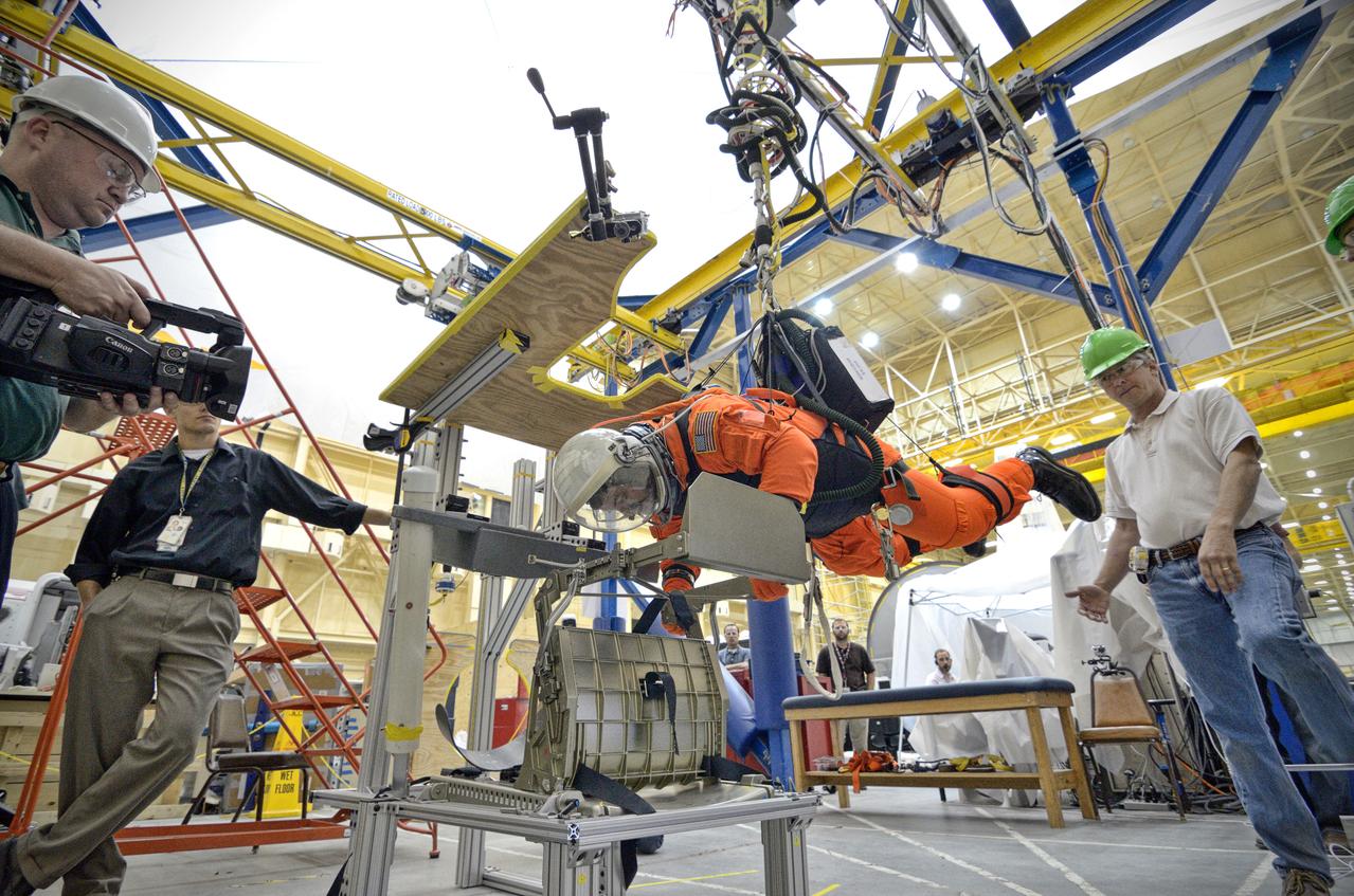 Astronaut Rex Walheim uses the Active Response Gravity Offload System (ARGOS) to perform early evaluations of the Orion Crew Survival System (OCSS) suit in Building 9 of Johnson Space Center in Houston on June 5, 2012. ARGOS is designed to simulate reduced gravity environments, such as lunar, Martian, or microgravity, using a system similar to an overhead bridge crane. Part of Batch image transfer from Flickr.