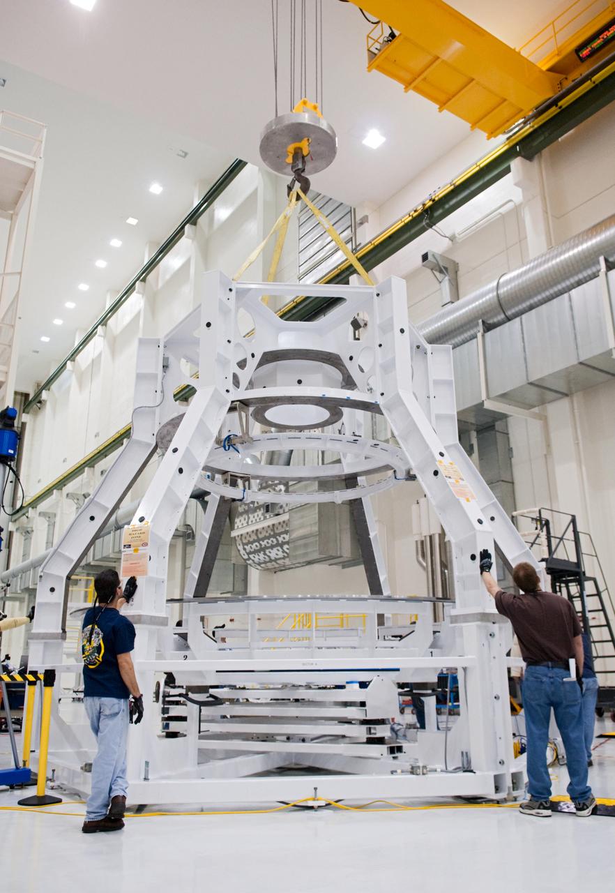 Orion technicians at the Operations and Checkout (O&amp;C) Facility at the Kennedy Space Center move the Orion Exploration Flight Test-1 (EFT-1) crew module from the clean room into the birdcage fixture on Dec. 5, 2012. The fixture is designed to enable precise pre-launch processing of the Orion spacecraft.