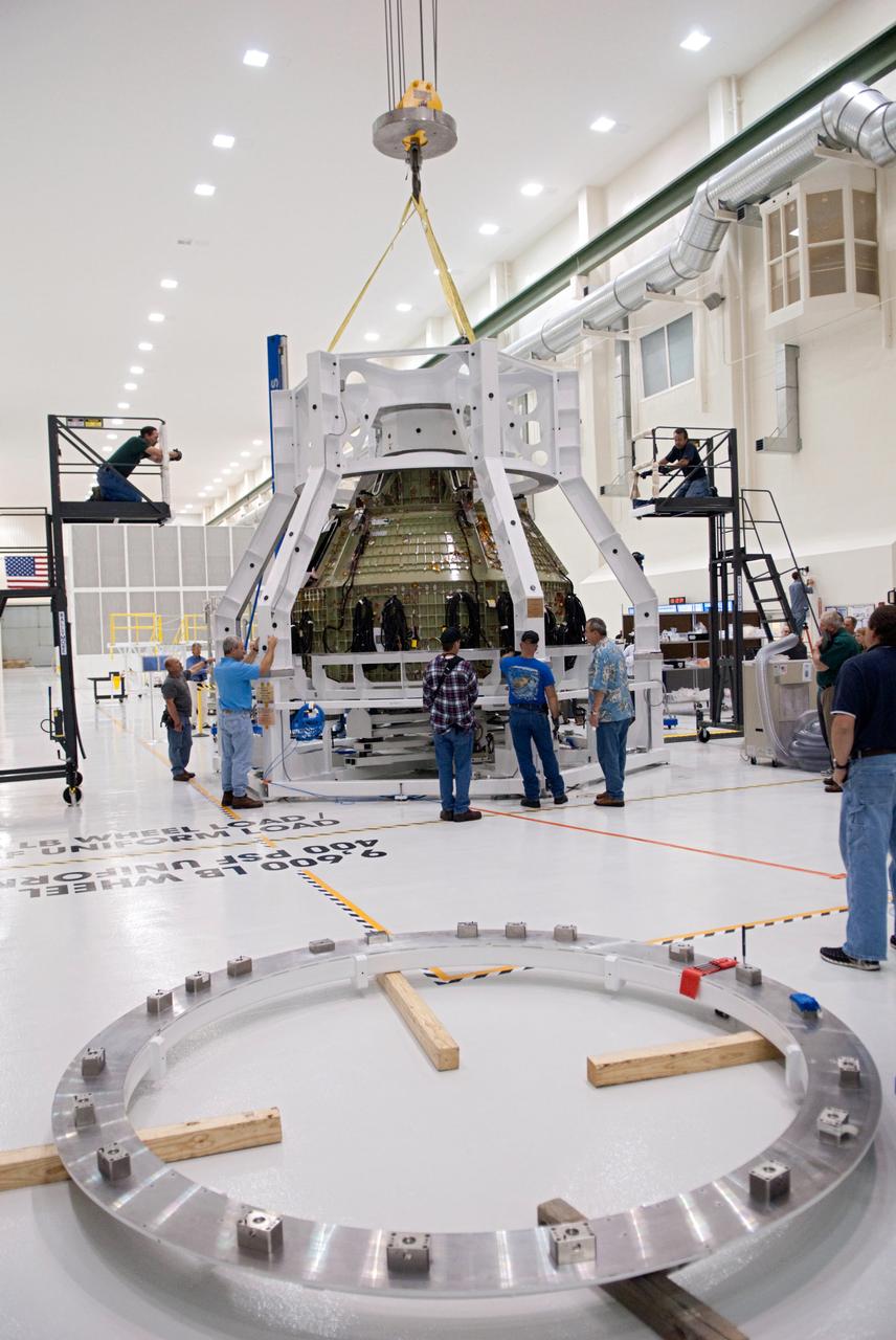 Orion technicians at the Operations and Checkout (O&C) Facility at the Kennedy Space Center move the Orion Exploration Flight Test-1 (EFT-1) crew module from the clean room into the birdcage fixture on Dec. 6, 2012. The fixture is designed to enable precise pre-launch processing of the Orion spacecraft. Part of Batch image transfer from Flickr.