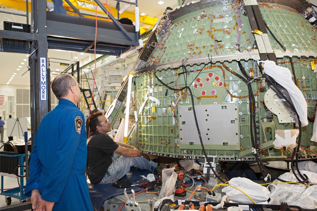 Work continues on the Exploration Flight Test-1 (EFT-1) Orion crew module in the Operations and Checkout Building (O&C) at Kennedy Space Center on March 21, 2013. Astronaut Don Pettit is visible talking to workmen. Part of Batch image transfer from Flickr.