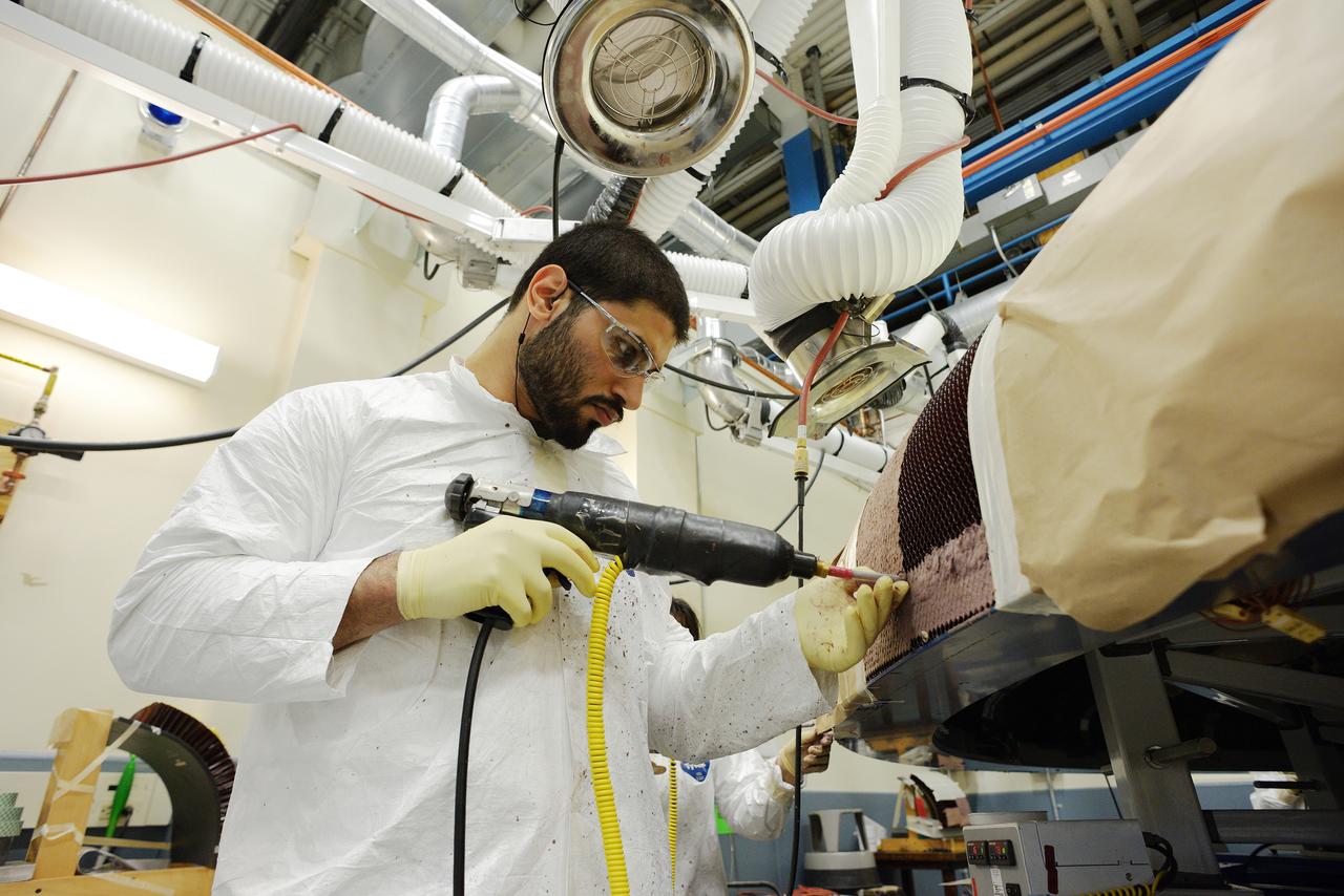 Technicians at Textron in Wimington, MA, apply Avcoat ablative material to the composite honeycomb structure attached to the Exploration Flight Test-1 (EFT-1) Orion heat shield carrier structure on May 22, 2013. Part of Batch image transfer from Flickr.