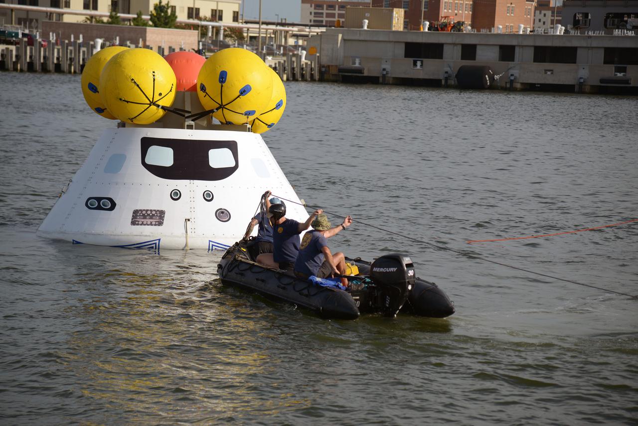 The Orion test capsule undergoes stationary recovery testing in Norfolk, VA on Aug. 13, 2013. NASA and the U.S Navy led the tests using the USS Arlington...The stationary recovery tests allow the teams to demonstrate and evaluate the recovery processes, the hardware and the test personnel in a controlled environment. ..During the test, the U.S Navy Dive Team checked the capsule for hazards while sailors from the USS Arlington approached the capsule in inflatable boats, and towed it back to the ship’s flooded well deck.  Part of Batch image transfer from Flickr.