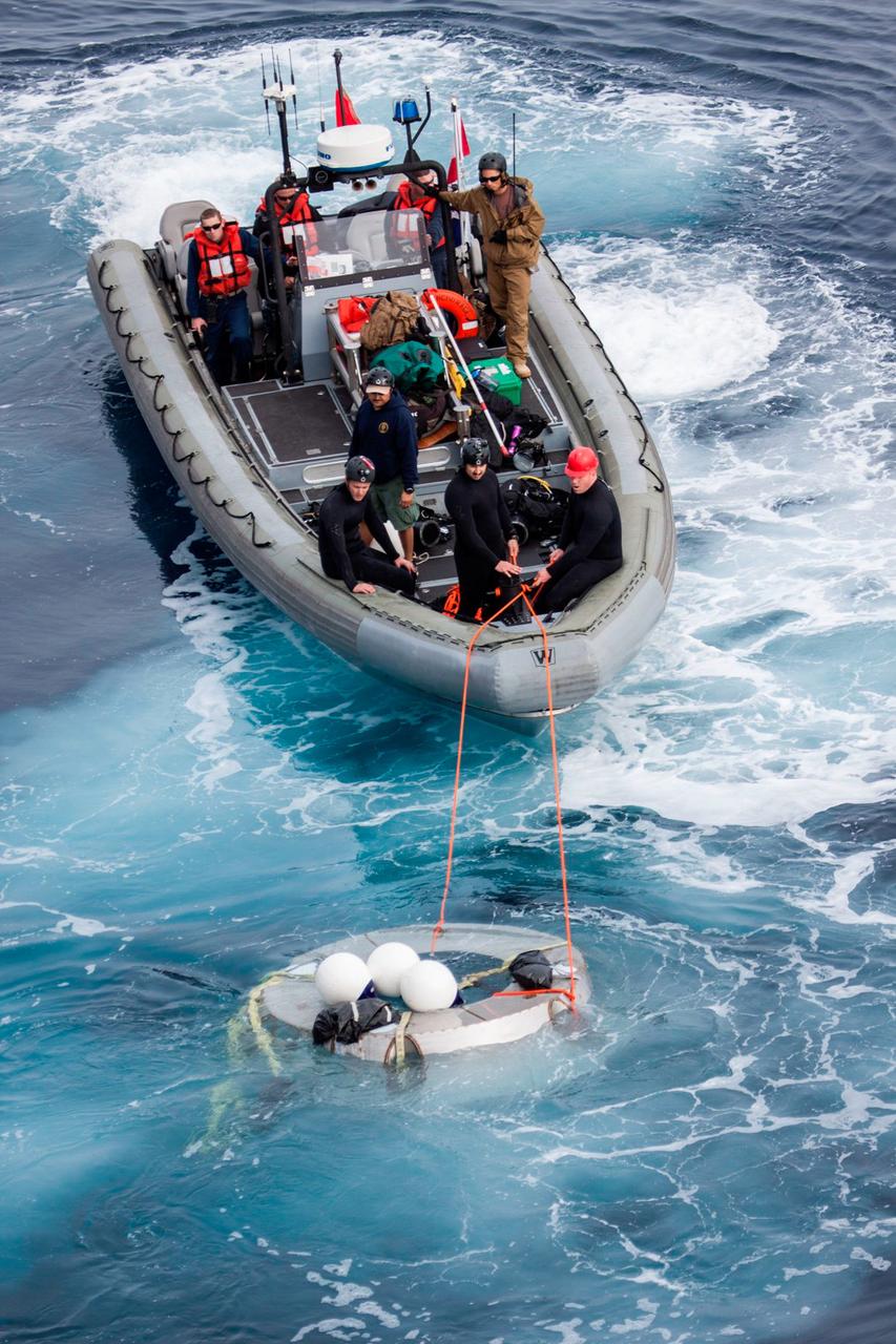 Members of the Orion recovery team work to retrieve a test version of Orion's forward bay cover, a protective shell that fits on top of the crew module, from the Pacific Ocean on Feb. 18, 2014, during an Underway Recovery Test. NASA and U.S. Navy personnel came together on board the USS San Diego, off the coast of California, to practice the processes they used to recover Orion after its splashdown following Exploration Flight Test-1 (EFT-1). Part of Batch image transfer from Flickr.
