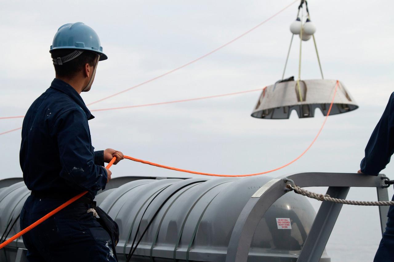 On the deck of the USS San Diego, NASA and U.S. Navy personnel monitor the process as a crane is used to lower Orion's forward bay cover into the Pacific Ocean as part of a Orion underway recovery test on Feb. 18, 2014. The Orion boilerplate test vehicle and other hardware were secured in the well deck of the ship in preparation for the test about 100 miles off the coast of San Diego, California. NASA and the U.S. Navy conducted tests to prepare for the recovery of the Orion crew module, forward bay cover, and parachutes on its return from a deep space mission. The underway recovery tests allow the teams to demonstrate and evaluate the recovery processes, procedures, hardware and personnel in open waters. Part of Batch image transfer from Flickr.