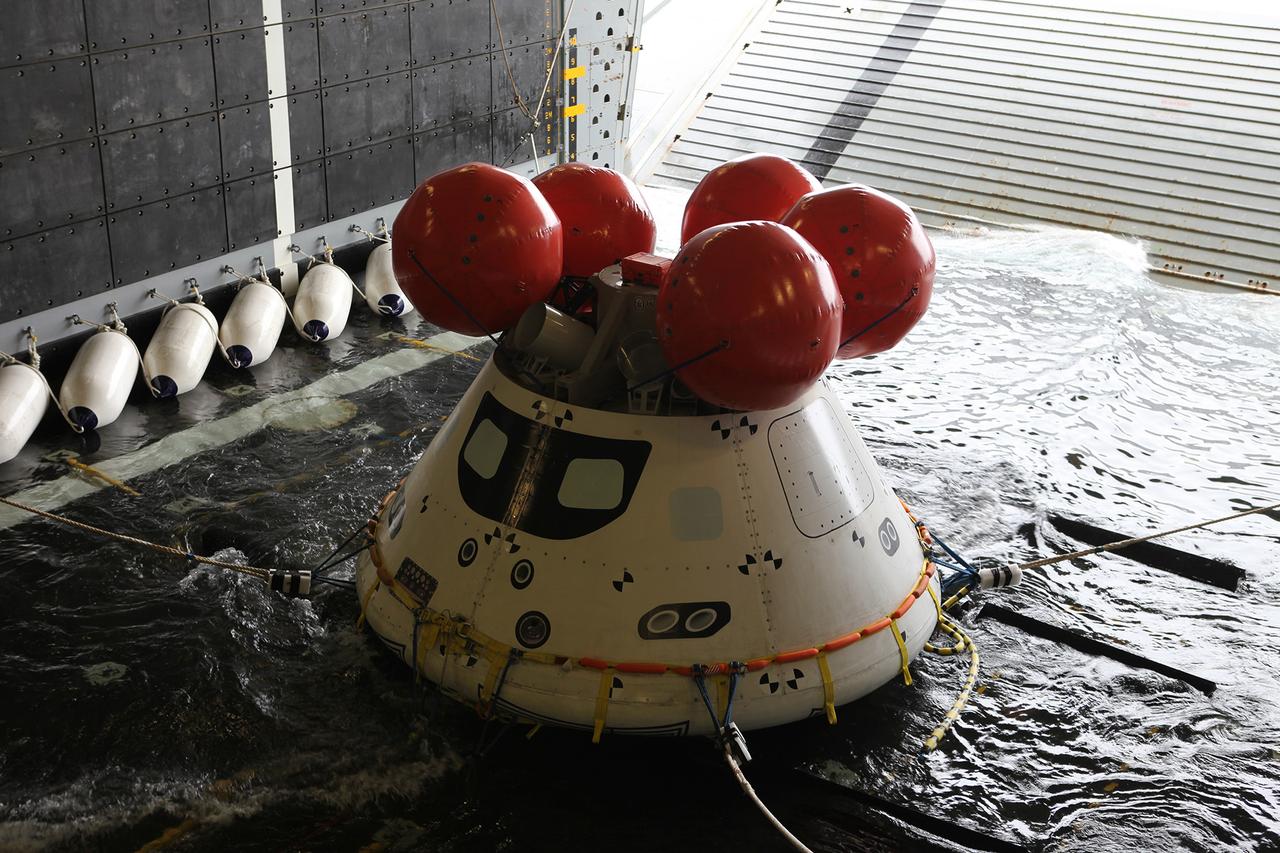 Recovery team members work with a test version of Orion floating in the well deck of the U.S.S. Anchorage on Aug. 2, 2014. A combined NASA and U.S. Navy team practiced recovery techniques off the coast of California in preparation for Exploration Flight Test-1 (EFT-1).  Part of Batch image transfer from Flickr.