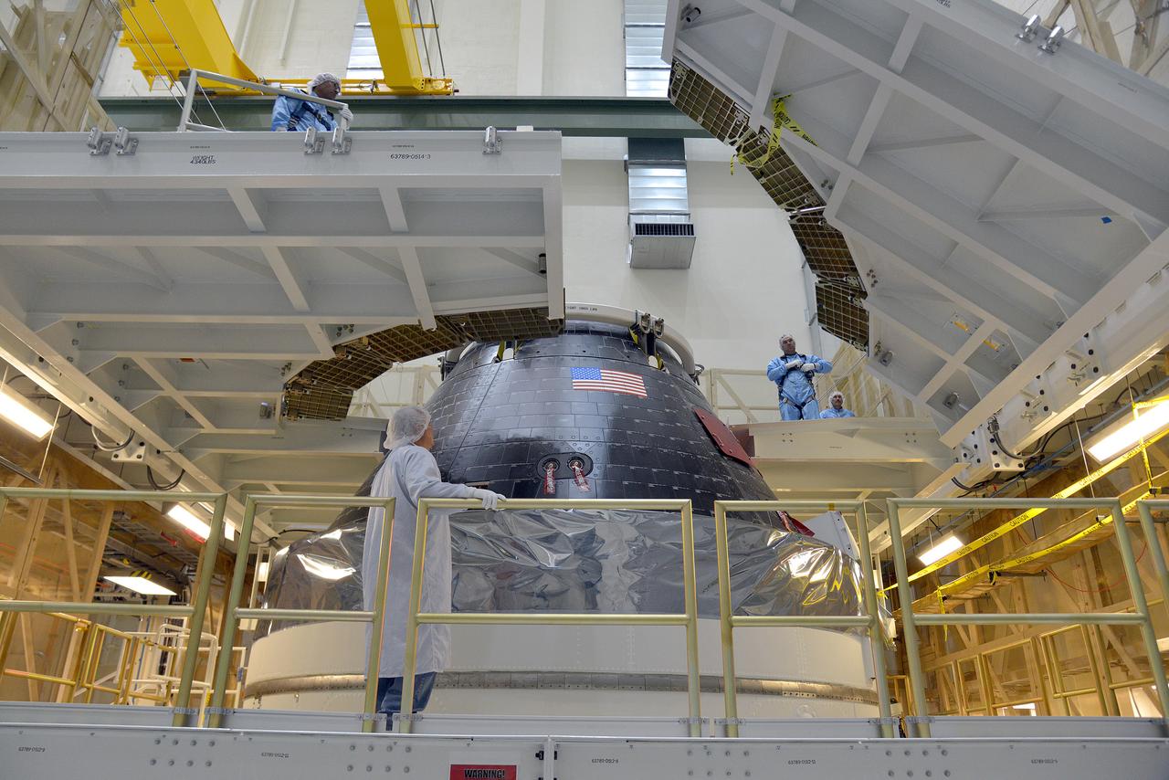 Technicians and engineers put finishing touches on the Orion Exploration Flight Test-1 (EFT-1) crew module and service module stack in the Operations and Checkout (O&C) Building at Kennedy Space Center on Sept. 7, 2014. Part of Batch image transfer from Flickr.
