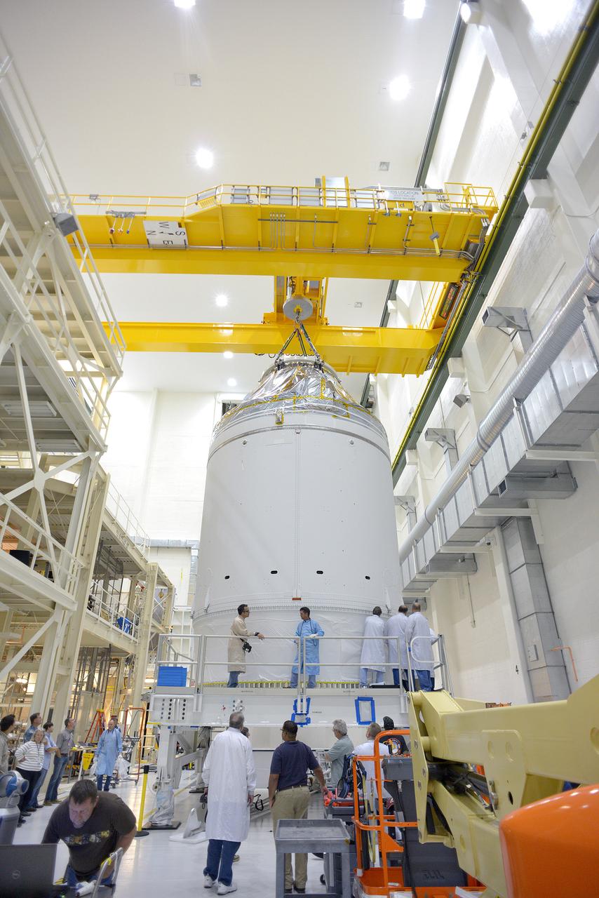 Technicians and engineers put finishing touches on the Orion Exploration Flight Test-1 (EFT-1) crew module and service module stack in the Operations and Checkout (O&C) Building at Kennedy Space Center on Sept. 7, 2014. Part of Batch image transfer from Flickr.