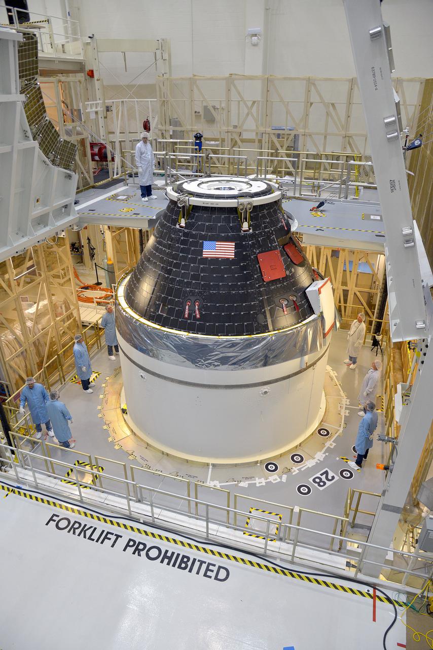 Technicians and engineers put finishing touches on the Orion Exploration Flight Test-1 (EFT-1) crew module and service module stack in the Operations and Checkout (O&amp;C) Building at Kennedy Space Center on Sept. 7, 2014. Part of Batch image transfer from Flickr.