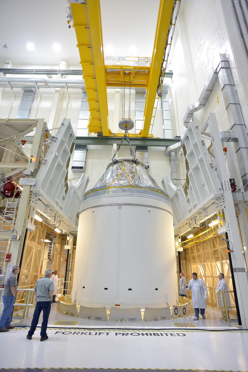 Technicians and engineers put finishing touches on the Orion Exploration Flight Test-1 (EFT-1) crew module and service module stack in the Operations and Checkout (O&C) Building at Kennedy Space Center on Sept. 7, 2014. Part of Batch image transfer from Flickr.