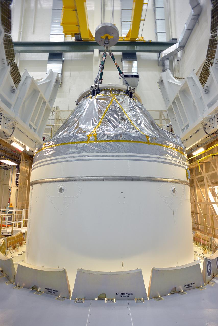 Technicians and engineers put finishing touches on the Orion Exploration Flight Test-1 (EFT-1) crew module and service module stack in the Operations and Checkout (O&C) Building at Kennedy Space Center on Sept. 7, 2014. Part of Batch image transfer from Flickr.