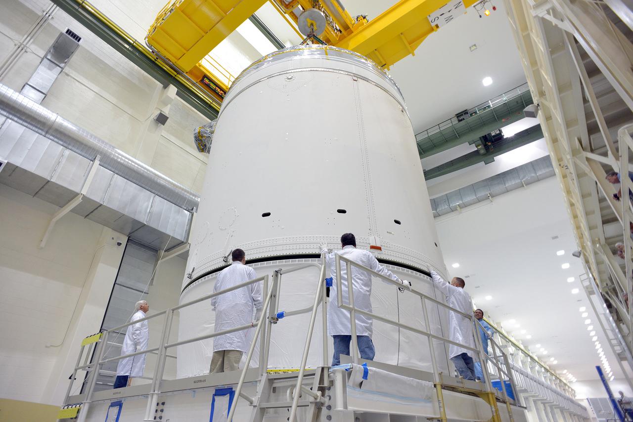 Technicians and engineers put finishing touches on the Orion Exploration Flight Test-1 (EFT-1) crew module and service module stack in the Operations and Checkout (O&C) Building at Kennedy Space Center on Sept. 7, 2014. Part of Batch image transfer from Flickr.