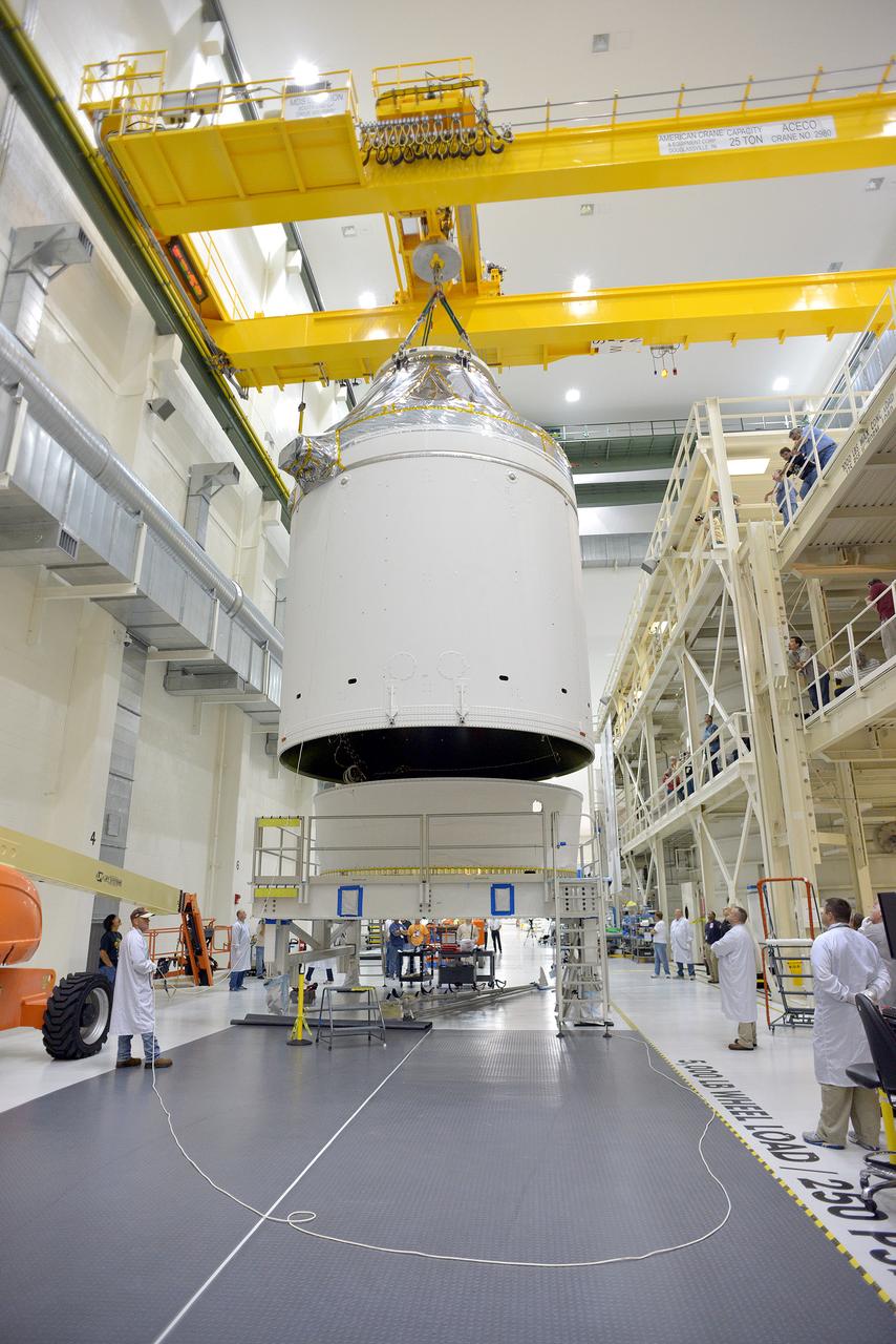Technicians and engineers put finishing touches on the Orion Exploration Flight Test-1 (EFT-1) crew module and service module stack in the Operations and Checkout (O&C) Building at Kennedy Space Center on Sept. 7, 2014. Part of Batch image transfer from Flickr.