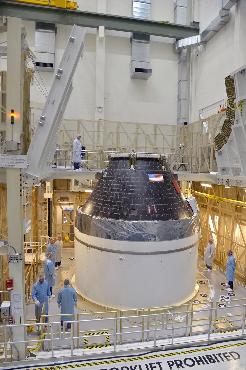 Technicians and engineers put finishing touches on the Orion Exploration Flight Test-1 (EFT-1) crew module and service module stack in the Operations and Checkout (O&amp;C) Building at Kennedy Space Center on Sept. 7, 2014. Part of Batch image transfer from Flickr.