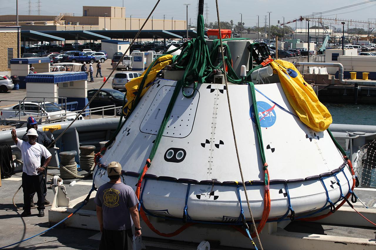 Recovery team members work secure a test version of Orion in preparation for tests aboard the USS Salvor on Sept. 12, 2014. A combined NASA and U.S. Navy team practiced recovery techniques off the coast of California over the course of the next week -- first with the crane, as seen here, then using the USS Anchorage's well deck -- in preparation for Exploration Flight Test-1 (EFT-1). Part of Batch image transfer from Flickr.