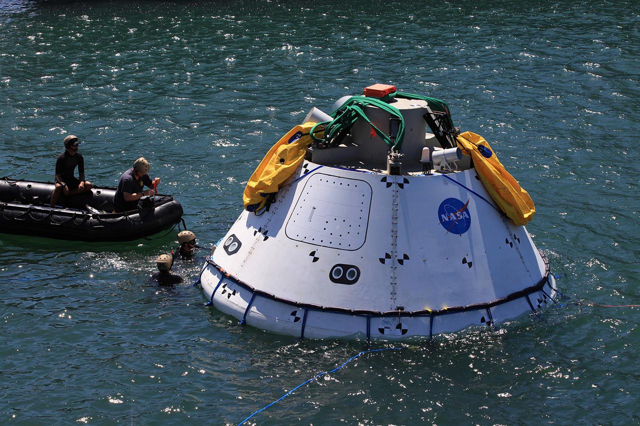 Recovery team members attach cables to a test version of Orion on Sept. 12, 2014. A combined NASA and U.S. Navy team practiced recovery techniques off the coast of California over the course of the next week -- first with the crane, as seen here, then using the USS Anchorage's well deck -- in preparation for Exploration Flight Test-1 (EFT-1).  Part of Batch image transfer from Flickr.