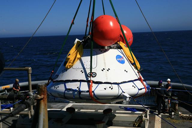 Recovery team members lower a test version of Orion onto the deck of the Navy's USS Salvor on Sept. 13, 2014. A combined NASA and U.S. Navy team is practiced recovery techniques off the coast of California over the course of the the week -- first with a crane on board the Salvor, then using the USS Anchorage's well deck -- in preparation for Exploration Flight Test-1 (EFT-1).  Part of Batch image transfer from Flickr.